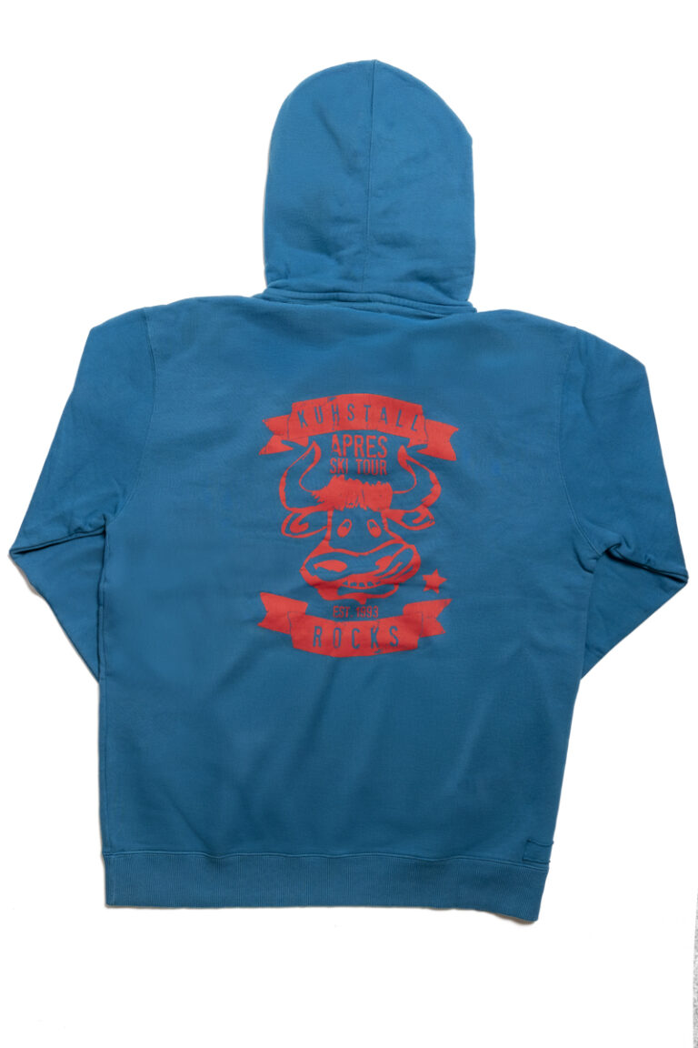 Der Herren Hoody blau von Kuhstall hat „Kuhstall“ in kräftigem Rot und Weiß auf der Vorderseite, eine Kapuze mit weißen Kordeln, ein kleines Logo auf dem linken Ärmel und eine gemütliche Kängurutasche. Das Innere ist mit leuchtend rotem Stoff gefüttert.