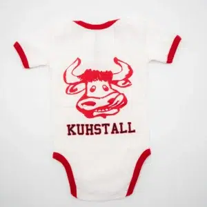 Kaufen Sie im Kuhstall Ischgl den „Kuhl Baby“-Strampler, einen weißen Baby-Body mit rotem Rand, der einen Kuhkopf im Cartoon-Stil zeigt und auf der Rückseite in kräftigem Rot „KUHSTALL“ aufgedruckt ist.